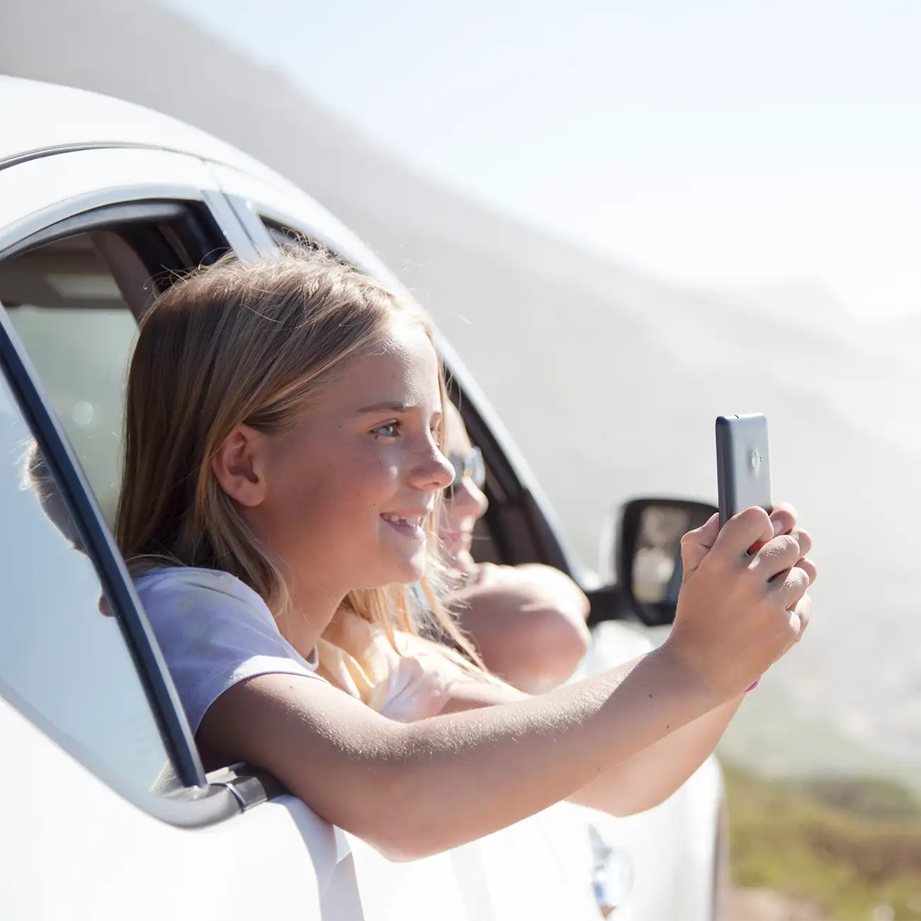 child taking photos from a rental car