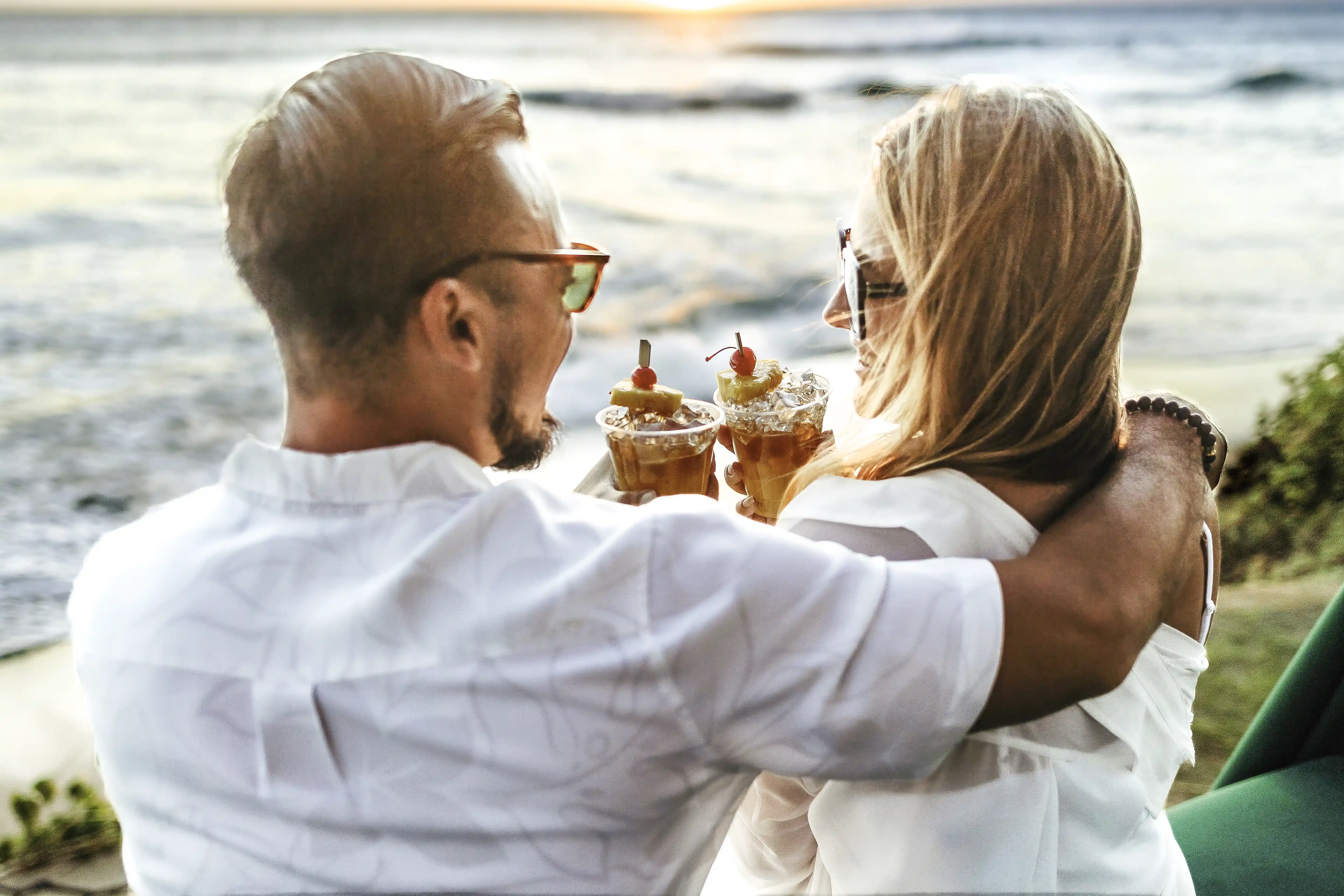 Couple toasting at sunset in front of an ocean